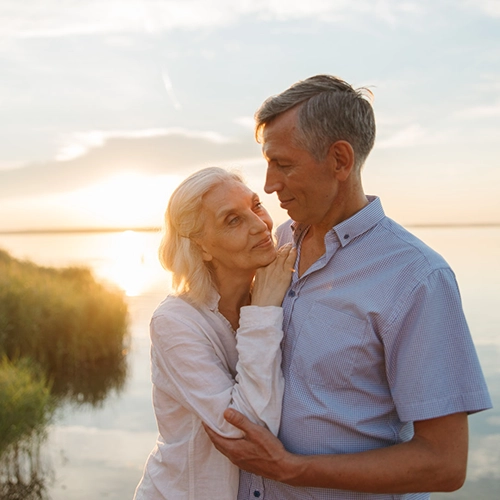 Elderly Couple Holding Each Other at Sunset